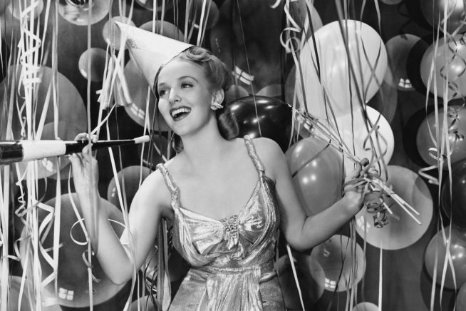 Retro image of girl having a party, with balloons in the background
